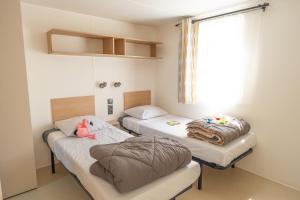 バラリュック・レ・バンにあるCamping Mas du Padreのベッド2台付きの部屋