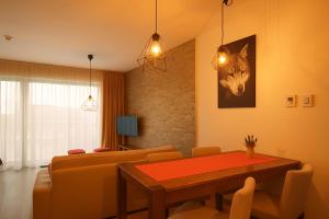 a living room with a table and a wolf picture at Apartmán Sivý vlk Hrebienok Rezort in Smokovce