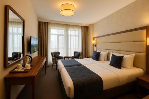 a hotel room with a large bed and a mirror at Istanbul Midpoint Hotel in Istanbul