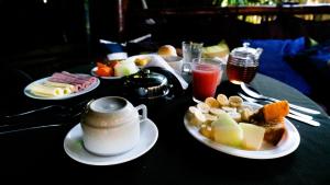 a table topped with plates of food and drinks at Canto Verde sua casa na ilha grande in Abraão