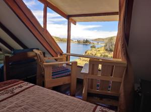a bedroom with a view of a river from a window at Ecolodge Aymara in Comunidad Challapampa