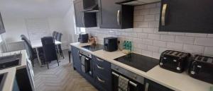 a kitchen with blue cabinets and a counter top at The Woodside in Cowdenbeath