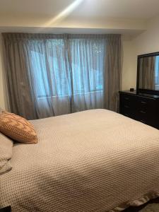 a bedroom with a bed and a flat screen tv at Stunning Lake Views in Queenstown +8 photos