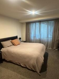 a bedroom with a large bed and a window at Stunning Lake Views in Queenstown