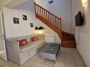 Una sala de estar con un sofá y una escalera. en Maison dans résidence mer - piscine, en Loc-Maria-Plouzané