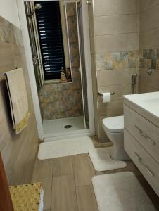 a bathroom with a shower and a toilet and a sink at casa cetta in Agrigento
