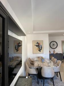 comedor con mesas y sillas y reloj en Appartement lumineux à 5 minutes de la gare, en Casablanca