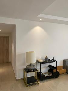 una sala de estar con una lámpara en una mesa en Appartement lumineux à 5 minutes de la gare, en Casablanca