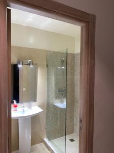 Un baño con ducha de cristal y lavabo. en Appartement lumineux à 5 minutes de la gare, en Casablanca 10 fotos más