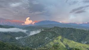 a view of a mountain with a fire in the distance at Hotel Reserva Monarca in Salento