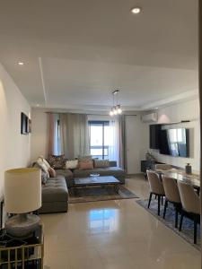 una sala de estar con un sofá y una mesa en Appartement lumineux à 5 minutes de la gare, en Casablanca