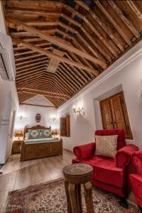 a bedroom with a bed and a red couch at Dar Chama in Chefchaouene +91 photos