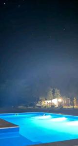 Una vista nocturna de una piscina con luces azules. en Lara cabañas, en Guaymallén 4 fotos más
