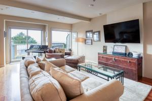 a living room with a couch and a flat screen tv at Stunning Oceanview Townhouse Walk to Seawall, Shops & Depoe Bay Dining in Depoe Bay