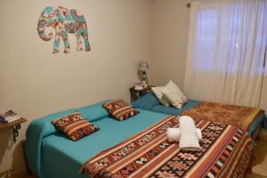 a bedroom with two beds and an elephant picture on the wall at Hotel Aparts Cabañas Tierra de Glaciares in El Calafate