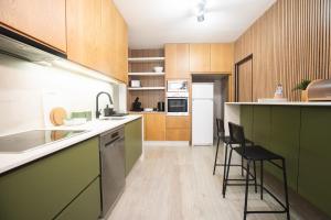 a kitchen with green and wooden cabinets and counters at Porto Panorama by Sira Stays in Porto