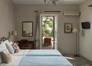 a bedroom with a bed and a door to a patio at Saint Louis in Andros