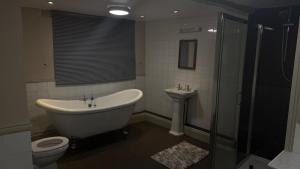 a bathroom with a tub and a toilet and a sink at The Red lion in Gloucestershire