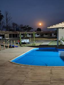 a blue swimming pool in a parking lot at night at Carolina Palace HOTEL in Carolina +11 photos