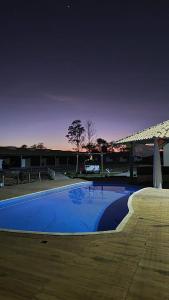 a large blue swimming pool next to a building at Carolina Palace HOTEL in Carolina