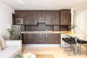 una cocina con armarios de madera y una isla de cocina en Marea, in the heart of the Atlantic, en Puerto Naos