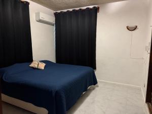 a bedroom with a blue bed with a black curtain at Departamento completo bien ubicado in Minatitlán