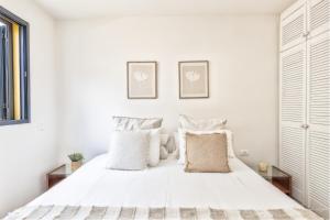 1 dormitorio blanco con 1 cama grande con almohadas blancas en Marea, in the heart of the Atlantic, en Puerto Naos 4 fotos más