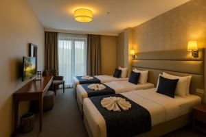 a hotel room with two beds and a desk at Istanbul Midpoint Hotel in Istanbul +72 photos
