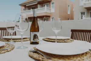 una mesa con copas y una botella de vino en Marea, in the heart of the Atlantic, en Puerto Naos