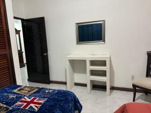 a room with a bed and a table and a television at Departamento completo bien ubicado in Minatitlán +2 photos