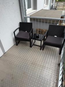 deux chaises et une table sur un balcon dans l'établissement Voll möblierte Gästewohnung in Magdeburg-Salbke, à Magdebourg