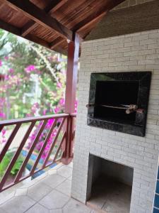 a brick oven on a patio with a railing at Cantinho da costeira in Bombinhas