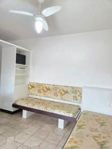 a bench in a room with a ceiling fan at Cantinho da costeira in Bombinhas +6 photos