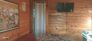 a room with a wooden wall with a television at recanto de pepe 1 in Santa Vitória do Palmar