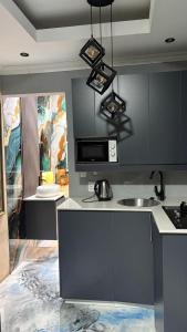 a kitchen with a sink and a counter top at Eccoo OR Tambo Airport lodge in Kempton Park