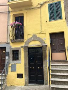 Bassano RomanoにあるCasa Yogaの黄色の建物(黒いドア、バルコニー付)