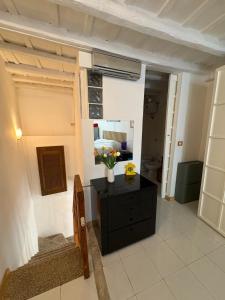 Bassano RomanoにあるCasa Yogaの花が飾られた黒いドレッサーのある部屋