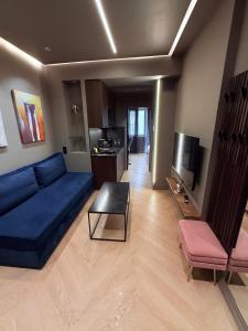a living room with a blue couch and a table at Brown Velvet Thess in Thessaloniki