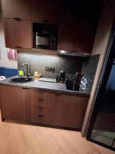 a kitchen with a sink and a microwave at Brown Velvet Thess in Thessaloniki