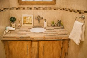 a bathroom sink with a wooden counter top at Hotel Aparts Cabañas Tierra de Glaciares in El Calafate +20 photos
