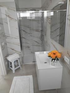 a bathroom with a white sink and a shower at La Tavernetta delle Terme Euganee in Montegrotto Terme +24 photos