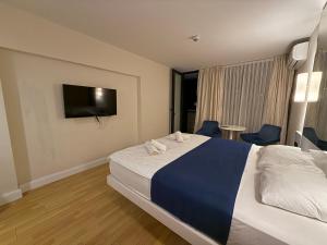 ein Hotelzimmer mit einem Bett und einem Flachbildfernseher in der Unterkunft Premium Sea Horizon Orbi City in Angisa