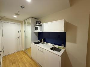 eine kleine Küche mit Spüle und Mikrowelle in der Unterkunft Premium Sea Horizon Orbi City in Angisa