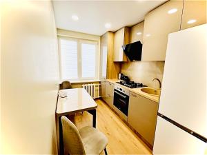 a small kitchen with a table and a sink at M&M Apartment VI SELF CHECK-IN in Panevėžys