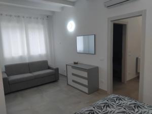 a living room with a couch and a dresser at La Tavernetta delle Terme Euganee in Montegrotto Terme