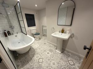 ein Badezimmer mit Waschbecken, Badewanne und Toilette in der Unterkunft Blackwood - Peaceful cottage surround by woodlands in Byfleet + 12 Fotos