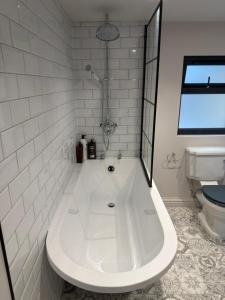 eine weiße Badewanne im Bad mit WC in der Unterkunft Blackwood - Peaceful cottage surround by woodlands in Byfleet