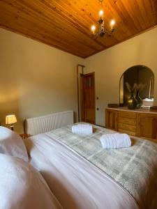 een slaapkamer met een groot wit bed met een spiegel bij Capris Rustic Ηouse with Mountain View in Archaia Feneos