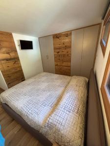 En eller flere senge i et værelse på Pragma Apartments - Wood Lodge Predazzo