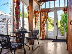 eine Veranda mit Stühlen, einem Tisch und Fenstern in der Unterkunft The Old Sweet Shop in Kings Lynn